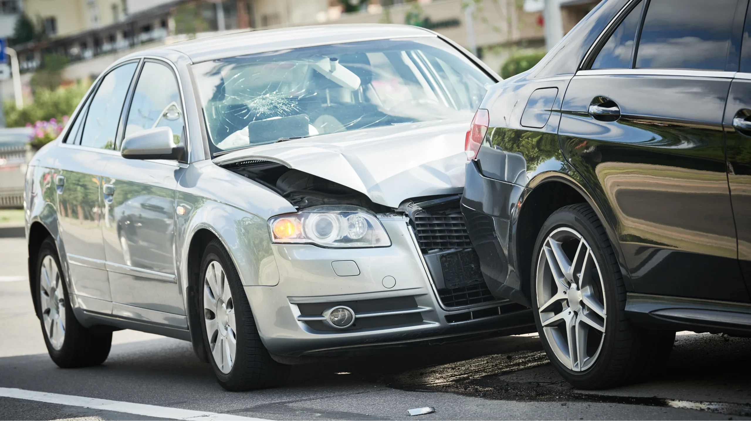 Rear-end collision between a silver sedan and black SUV