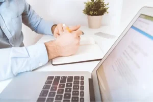 hand-writing-in-notebook-beside-laptop What Happens to Your Claim If the Other Driver Had No Insurance?