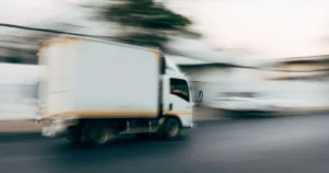 box-truck-driving-on-city-street Box delivery truck driving on a city street