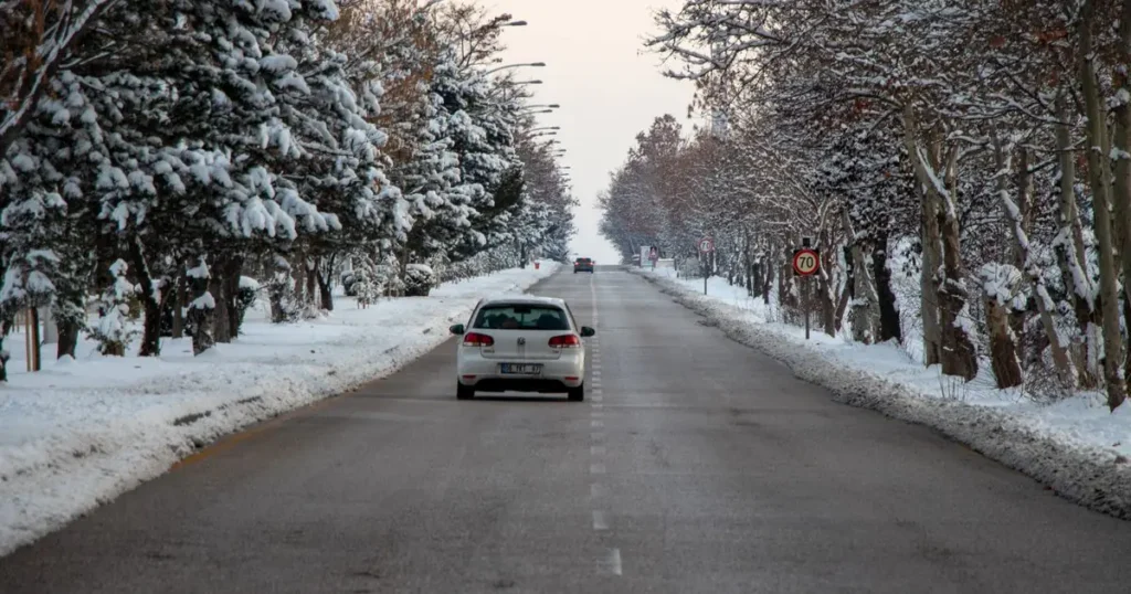 Car driving on a snow-lined winter road