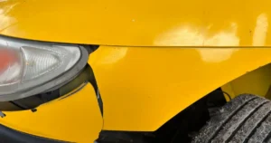 damaged-car-bumper-close-up Close-up of a damaged car bumper and headlight