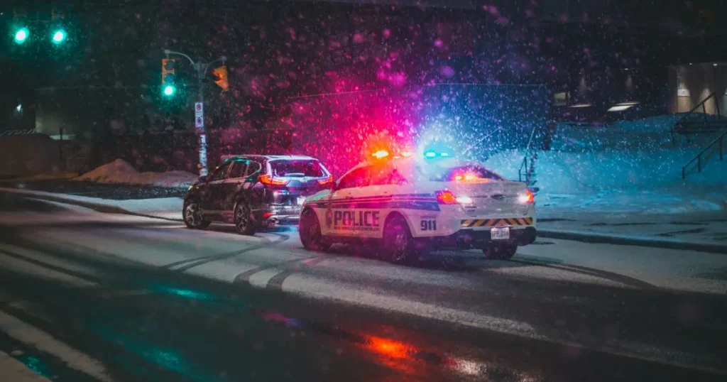 Police car with emergency lights on a snowy night